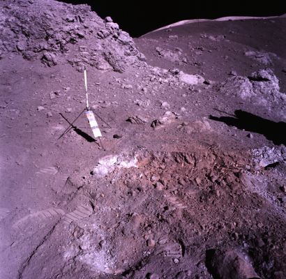 APOLLO 17 AS 17-137-20990 - Shorty Crater and the Lunar "Orange Soil"
Dall'Apollo Lunar Surface Journal - Mission Summary -, di Eric M. Jones:"(...)
The patch of orange seemed to form a band that ran parallel to the rim of the crater and as Schmitt dug a trench across the band, it became evident that, under a thin layer of altered surface soil, the ground was a deep red at the center of the band, fading to orange toward the edge. By the time Schmitt had finished the trench, Cernan had finished dusting the TV camera - so that Houston could have a good look - and arrived with the gnomon and a supply of sample bags. The gnomon was a lovely little device consisting of a free-swinging staff mounted on a tripod base (...) On Earth, orange or rust-colored rocks and soil around volcanic vents are often the result of literal rusting of iron by volcanic water vapor. If this was the cause of the orange soil at Shorty then, small amounts of volcanic gasses might still be present (on the Moon)...". 
Parole chiave: Postcards from the Moon