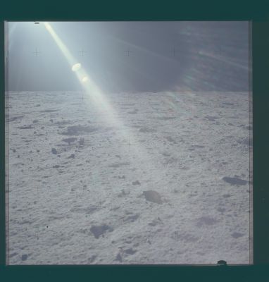 AS 11-40-5936 - Up-Sun (2)
110:55:49 MT. Rightward of 5935 but without overlap because Neil has avoided the up-Sun view. The Southern part of East Crater on the lefthand side of the image. Part of the rim of West Crater can be seen faintly just above center. We can locate the approximate azimuths of the north and South rims of West Crater from Figure 3-15 in the Apollo 11 Preliminary Science Report and a detail from the USGS site map.
As indicated in Figure 3-15, Neil took the minus-Z pan from a location about 20 meters roughly southeast of the LM. The exact location has been added to the inset at the upper right, which shows that Neil was about 55 meters due west of the south rim of East Crater. From the site map detail we see that, from the south rim of East Crater, the north rim of West Crater is about 460 meters away on an azimuth of about 92.7 degrees. With the help of a little trigonometry, this information gives an azimuth of the north rim of West Crater from Neil's location of 92.4 degrees, with the south rim azimuth being about 112.4 degrees. During the Apollo 11 EVA, the solar azimuth was 88.1 degrees, which allows us to plot the relevant azimuths on a detail from 5936. The plotted azimuth for the south rim is very close to the lefthand edge of the horizon feature that is obviously a partly shadowed portion of the rim while the plotted north rim azimuth is close to the righthand edge of what is probably a sunlit, rock-strewn portion of the rim.
Parole chiave: Lunar Panorama - Apollo 11 Landing Site