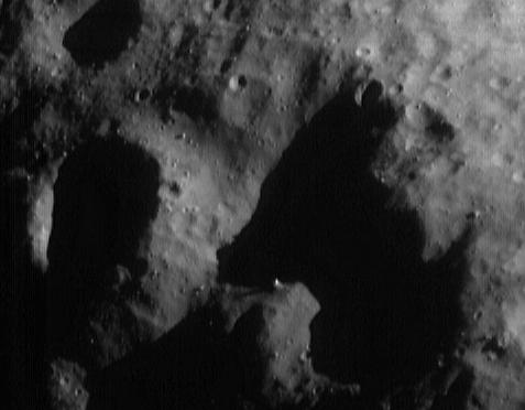 A strange drawing made by lights and shadows...
Eros' irregular shape creates interesting and beautiful scenes where the Sun shines obliquely on the surface. In the absence of an atmosphere, and hence no secondary illumination reflecting from atmospheric molecules, shade appears nearly as black as space. This image, taken from the NEAR Shoemaker spacecraft on May 2, 2000, from an orbital altitude of 50 kilometers (31 miles), shows one of the more telling and yet comical combinations of light and shadow. The entire scene is about 1.8 kilometers (1.1 miles) across. High spots near the edges of shadows, like the 35-meter (115-foot) diameter boulder just below the center of the frame, seem almost to "float" above the surface. With a little imagination, the shadow dominating the right side of the frame could be seen as a small, long-eared terrier bending over to sniff his dinner!
Parole chiave: Asteroids: images from Space