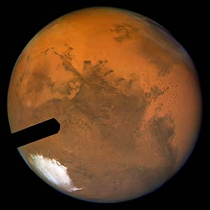 Mars from Earth
Una visione solo apparentemente identica alla precedente: in questo secondo caso, infatti - anche se stentiamo a crederlo... - l'immagine arriva da Terra! L'inclinazione dell'asse del Pianeta Rosso è diversa; la calotta Sud-Polare ci appare un pò più sviluppata rispetto a quanto si vedeva nell'immagine HST ed anche la circonferenza del Pianeta sembra leggermente più grande. La definizione è addirittura migliore rispetto al frame HST; il colore della superficie di Marte è più intenso ed i bordi azzurri (blue limbs) sono spariti. 
Domanda: ma quale delle due immagini è più veritiera?
Parole chiave: From Earth Images