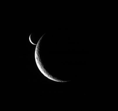 After the occultation...
Caption NASA originale:"Two slim crescents smile toward the Cassini spacecraft following an occultation event. 
Taken only 5 minutes after Enceladus first approached the limb of Rhea, this view shows the bright little moon emerging from behind the larger moon's crescent.

The image was taken in visible light with the Cassini spacecraft narrow-angle camera on July 4, 2006 at a distance of approx. 1,4 MKM (about 800.000 miles) from Rhea and approx. 1,9 MKM (about 1,2 MMs) from Enceladus. The view was obtained at a Sun-moon-spacecraft, or phase, angle of about 142° relative to both moons. 
Image scale is about 8 Km (5 miles) per pixel on Rhea and approx. 11 Km (about 7 miles) on Enceladus".
Parole chiave: Saturn's Moons - Rhea and Enceladus