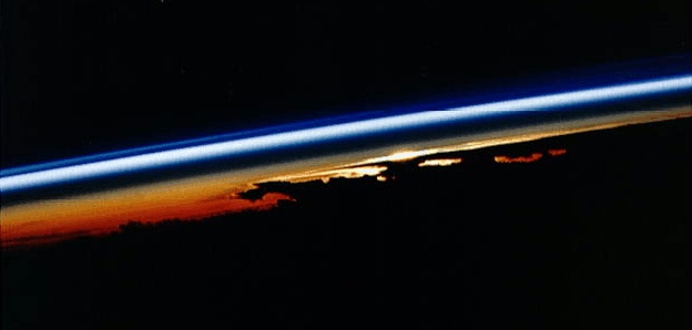 Sunrise from space...
Caption NASA originale:"Sunrise seen from low Earth orbit by the shuttle astronauts can be very dramatic indeed. In this view, the Sun is just visible peaking over towering anvil-shaped storm clouds whose silhouetted tops mark the upper boundary of the troposphere, the lowest layer of planet Earth's atmosphere. Sunlight filtering through suspended dust causes this dense layer of air to appear red. In contrast, the blue stripe marks the stratosphere, the tenuous upper atmosphere, which preferentially scatters blue light". 
Parole chiave: Postcards from Space