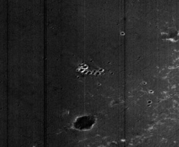 Bizarre-looking Features in Terra Meridiani (Original NASA/MGS/MSSS b/w M0705535 - EDM n.1)
La natura craterica del rilievo, dopo il detail mgnf, ci sembra difficile da mettere in dubbio; tuttavia la conformazione/configurazione di questo Crater Cluster, unita alla luminosità apparente dei bordi dei crateri che lo formano, rendono l'immagine - come spesso accade... - accattivante ed oltremodo misteriosa.
In realtà, usando un pizzico di immaginazione, potremmo anche vedere un agglomerato - ben illuminato! - di costruzioni a forma di igloo: molti Ricercatori, esaminando immagini come queste, sovente si addentrano in profonde e pericolose costruzioni speculative per il piacere (forse un pò perverso) di sorprendere e di stimolare dei contraddittori...
A noi però sembra più interessante ed importante rimanere pragmatici e limitarci a sottolineare questa ennesima Singolarità Marziana!
Parole chiave: Mars from orbit - Terra Meridiani - Controversial Features