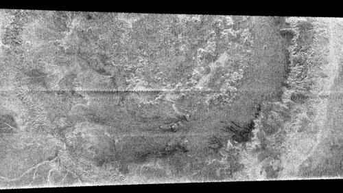 Impact Crater?
Caption NASA originale:"A huge annular feature with an outer diameter of approximately 440 kM (approx. 273 miles) appears in this image taken with Cassini's Titan radar mapper. It resembles a large crater or part of a ringed basin, either of which could be formed when a comet or asteroid tens of Kms in size slammed into Titan. This is the first impact feature identified in radar images of Titan. The surface of Titan appears to be very young compared to other Saturnian satellites. In Titan's case, debris raining down from the atmosphere or other geologic processes may mask or remove the craters. The pattern of brightness suggests that there is topography associated with this feature; for example, in the center of the image there appear to be mounds each about 25 Km across. Since they are dark on their lower edges that face away from the radar and bright on the opposite face, they must be elevated above the surrounding terrain". 
Parole chiave: Saturn's Moons - Titan