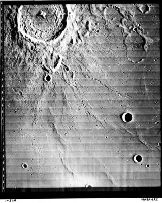 Taruntius Crater form Lunar Orbiter 1
Caption NASA originale:"Lunar Orbiter 1 image of Taruntius crater on the Moon. The crater at the top of the image is 56 km in diameter. Note the central peak and internal concentric ridges and rilles. North is up. (Lunar Orbiter 1, frame M-31)".

Location & Time Information
Date/Time (UT): 1966-08-20 T 13:46:59
Distance/Range (km): 247
Central Latitude/Longitude (deg): +02.54/047.96
Parole chiave: Moon from orbit