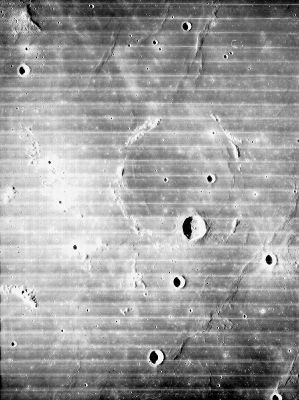 Flamsteed Crater and Oceanus Procellarum
Caption NASA originale:"Lunar Orbiter 4 image showing the 20 Km Flamsteed Crater on the Moon. Flamsteed is the large crater near the bottom of the image. A broken ring of bright ridges, probably the rim of an older crater nearly covered by the later Oceanus Procellarum mare basalts, can be seen. The ring is about 100 Km in diameter, and a concentric wrinkle ridge is evident within the ring. The Surveyor 1 spacecraft landed in the upper right portion of the ring. North is up (Lunar Orbiter 4, frame 143-H2)".

Location & Time Information
Date/Time (UT): 1967-05-21 T 17:28:22
Distance/Range (km): 2719
Central Latitude/Longitude (deg): -14.30/318.59
Parole chiave: Moon from orbit