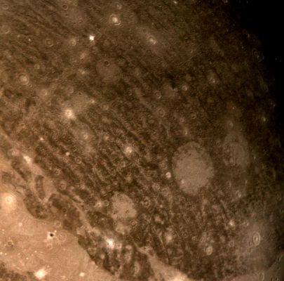 Ganymede (Enhanced Natural Colors and HR; credits: NASA/JPL)
Caption NASA originale:"This color reconstruction of part of the Northern Hemisphere of Ganymede was made from pictures taken from a range of about 313.000 Km (approx. 194.000 miles). 
The scene is approx. 1.300 Km (about 806 miles) across and it shows part of dark, densely cratered block which is bound on the south by lighter and less cratered, grooved terrain. 
The dark blocks are believed to be the oldest parts of Ganymede's surface. Numerous craters are visible, many with central peaks. The large bright circular features have little relief and are probably the remnants of old, large craters that have been annealed by flow of the icy near-surface material. 
The closely-spaced arcuate, linear features are probably analogous to similar features on Ganymede which surround a large impact basin. 
The linear features here may indicate the former presence of a large impact basin to the South-West".
Parole chiave: Jupiter's Moons - Ganymede
