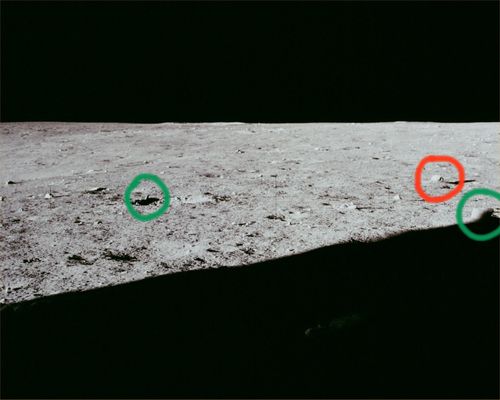 AS 12-46-6745 - Horizon and strange stones (2) - HR
Cerchiatura Verde (Sx): la roccia appuntita che Vi avevamo già fatto notare nel frame precedente;

Cerchiatura Verde (Dx): un boulder a forma tronco-colonnare di modeste dimensioni (stimiamo tra i 40 ed i 50 cm);

Cerchiatura Rossa: apparentemente si tratta di una roccia (sempre dalla forma curiosa - diremmo a "tettoia spiovente") con "foro" che ci ricorda tantissimo un'altra roccia bucata rinvenuta su Marte, nei primissimi Soles di Spirit (vedere le immagini ed i detail mgnf proposti da Fabio Italiano nella Sezione "Mars in Colors"). 
Potrebbe anche trattarsi, tuttavia, di una illusione ottica determinata dall'immagine sfuocata (come Conrad stesso ammette, a causa di un suo errore) oppure di un'altra piccola pietra la quale, rispetto all'angolo di ripresa, si superimpone alla roccia a tettoia e, sempre grazie alla sfuocatura, ci appare come non come oggetto indipendente, bensì come dettaglio (curioso) del corpo maggiore più lontano. 
Forse quest'ultima interpretazione è da preferirsi.
Parole chiave: Lunar Surface - rocks and anomalous features