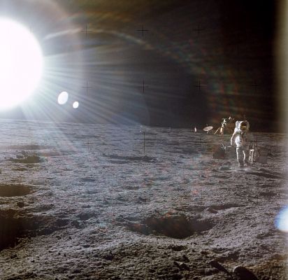 AS 12-46-6806 - Alan Bean carrying the ALSEP
Al is carrying the ALSEP package out from the LM. As can be seen in a detail, he is walking flat-footed, in part because the mass of the ALSEP packages is nearly the same as the combined mass of him and his suit and backpack and, in part, because the carrybar is flexing and would be difficult to control if he tried to use a loping stride. Note that he is holding the carrybar in his hands, with his arms hanging down in front of him. Other LMPs discovered that it was easier to carry and control the packages by holding their arms up in front of them and getting the carrybar in the elbow crooks. Note the flag and the S-Band antenna to the left of the LM.
Parole chiave: Lunar equipment, tools and materials