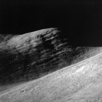 AS 15-84-11250 - Silver Spur (HR)
Original caption:"Dave Scott took this 500-mm picture of Silver Spur during the SEVA at about 106:58:07 MT. Silver Spur is named for Caltech geologist Lee Silver, who showed Scott and Irwin that field geology could be exciting (see Don Wilhelm's excellent book "To a Rocky Moon").
Note that there appear to be 2 systems of lineations in Silver Spur. One set consists of what appear to be about ten thick beds which appear to dip down from right to left as seen from the LM. As discussed in the Apollo 15 Preliminary Science Report, this set of lineations may well represent real structure in the mountain. 
The second set of lineations consists of closely-spaced, nearly horizontal lines and these lines may be lighting artifacts". 

Scan courtesy NASA Johnson.
Parole chiave: Lunar Surface Features - Silver Spur