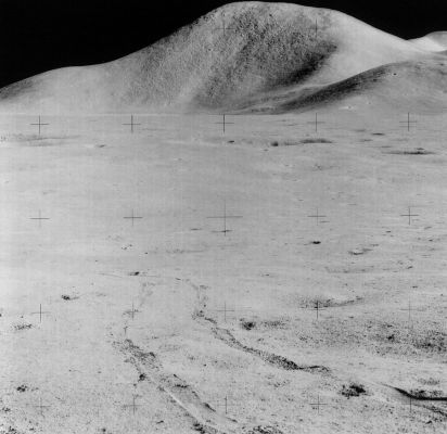 AS 15-85-11488 - Western side of Mt Hadley
Caption NASA originale:"This frame is part of Jim's first Station 6 pan and shows the now-sunlit western face of Mt. Hadley. 
The lineations (---->striature) visible on the mountain are generally believed to be a lighting effect due to the long shadows cast by small-scale undulations at this very-low sun angle. In the foreground we can see the tracks made by the Rover as Dave and Jim approached Station 6".
Parole chiave: Mount Hadley