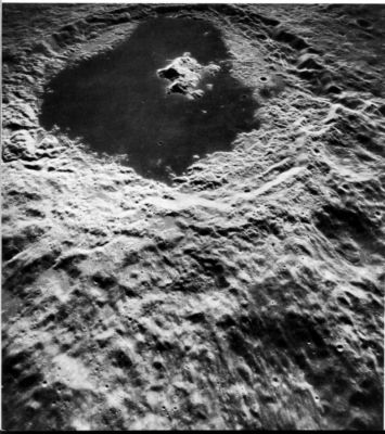 AS 15-0757 - Tsiolkovsky
Tsiolkovsky is one of the most prominent features on the Far-Side of the Moon. It is a 1 90-Km- wide impact crater with a large, complex central peak that is offset from the apparent center of the crater. Differences in tone and texture between the central peak, the lava-flooded floor, the terraced walls and the ejecta blanket are dramatically displayed in this oblique view. The ejecta blanket is dominated by a coarse pattern of ridges radiating outward from the crater; superposed on this pattern are many small level pools of smooth material that are much lighter than the otherwise similar smooth dark mare in the floor of Tsiolkovsky. The pools probably originated differently. They may consist of rock that was melted by the heat and pressure generated during the impact event and that flowed into depressions before it hardened.

Cratering experiments on Earth have shown that central peaks consist of bedrock that has been displaced upward by a distance equal to about 1/10th the diameter of the resulting crater. If samples could be obtained from the central peak at Tsiolkovsky, they might be rocks that were 20 km below the Moon's surface before Tsiolkovsky was created.
Parole chiave: The Moon from orbit - Craters - Tsiolkovsky