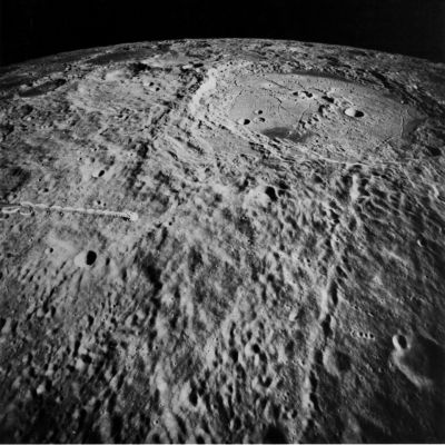 AS 15-2510 - Humboldt Crater
The crater Humboldt, on the east limb of the Moon, as seen from Earth, is 200 km across, a little larger than Tsiolkovsky. This view by the Apollo 15 mapping camera looks southward across Humboldt's ejecta blanket and into the crater. Irregular secondary craters partly covered by the ejecta are in the foreground and a long chain of secondaries extends from Humboldt's rim to the foreground. Humboldt is one of the largest craters known to have a prominent central peak. If the crater is like terrestrial impact structures, the peak may expose rock uplifted about 10% of the crater's width, on the order of 20 Km from beneath the crater floor. This would be an exciting find for future Astronauts. A spider web of cracks on the crater floor suggested to R. B. Baldwin (1968) that the floor was bowed up in the middle. Later, dark mare lavas flooded low areas in the outer part of the floor and covered the cracks. A peculiar "bull's eye" double crater on the crater floor has several counterparts elsewhere on the Moon. The origin of these double craters is a continuing puzzle.
Parole chiave: The Moon from orbit - Craters - Humboldt