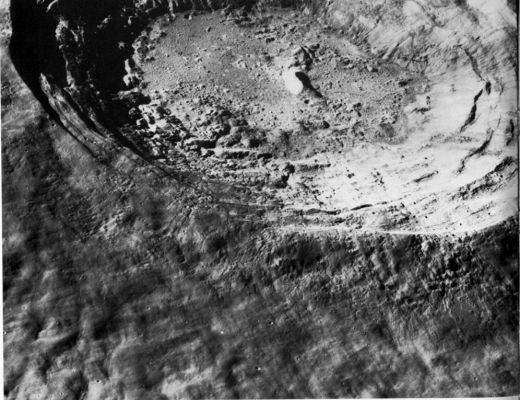 APOLLO 15-0326 - Aristarchus
Aristarchus is a large crater on the edge of a plateau within Northern Oceanus Procellarum. In this scene the crater is viewed obliquely from the North. One of the brightest and youngest craters of its size on the Near-Side of the Moon, Aristarchus is believed to be younger even than Copernicus. The general appearance of Aristarchus and of parts of the plateau around it led Alfred Worden, the Apollo 15 CMP, to describe this part of the Moon as "... probably the most volcanic area that I've seen anywhere on the surface". For many years before the Apollo Missions, Earth-based viewers had reported telescopic sightings of TLP's centered on Aristarchus. These brief, subtle changes in color or in sharpness of appearance have been suggested as evidence for volcanic activity or the venting of gases from the lunar interior. The sightings are controversial, but Aristarchus remains a center of interest.
About 39 Km in diameter, Aristarchus is on the borderline between medium-sized and large- sized craters. We have included it among the large craters because its welldeveloped concentric terraces are characteristic of most large craters that have not been too severely degraded. Its terraced walls, as well as its arcuate range of central peaks, are particularly well shown in this view. The walls and parts of the crater floor are extremely rough and cracked, a characteristic feature of other young impact craters of this size range, such as Tycho and Copernicus. The rough deposits in the floor are probably made up largely of shockmelted material formed at the time of the impact. The inner, rougher portions of the rim show a series of channels, lobate flows, and smooth puddlelike deposits that may represent shock-melted material deposited on the crater rim. The outer, smoother portions show the rhomboidal pattern characteristic of crater ejecta blankets.
Parole chiave: The Moon from orbit - Craters - Aristarchus
