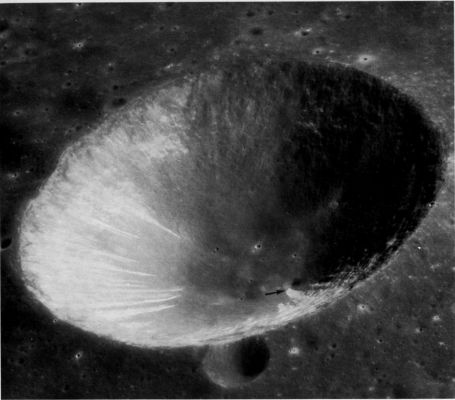 AS 16-4502 - The beautiful Isidorus "D"
This oblique view of the crater Isidorus "D" was taken with the PanCam on Apollo 16. Isidorus "D" is about 15 Km in diameter and is located in the highlands between Mare Tranquillitatis and Mare Nectaris. 
Evidence of avalanching (Howard, 1973) and of other types of downslope movement of material are clearly visible on the inner walls of the crater. The streaks resembling shooting stars on the left wall appear to be avalanche scars. The avalanches probably were spearheaded by large blocks followed by fine-grained material. On the near wall (arrow) a larger landslide terminates in a straight line against the relatively flat crater floor. In the shadowed part of the crater wall many short irregular benches or narrow terraces mark the tops of masses of slumped material. The brightness of the avalanche scars is an indication of their freshness; in general, freshly exposed lunar materials are brighter than undisturbed materials nearby.
Parole chiave: The Moon from orbit - Craters - Isidorus "D"