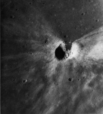AS 16-4511 - Crater "Rays"
This picture shows the striking bilateral symmetry of the rays of a small (2-Km diameter) crater in the floor of the large crater Daguerre in Mare Nectaris. Continuous areas and narrow filaments of light-gray ejecta extend from the crater across the dark mare surface through 270°, but are entirely absent in the southern 90° sector. Within the crater, dark material occurs on the southern crater wall while the remaining walls are bright. (The reader may wonder about the material whose reflectivity cannot be observed because it lies in shadow on the East wall of this crater. Until the area is observed under high Sun conditions, we are forced to make the simplifying assumption that it is bright because most of the materials visible elsewhere in the walls are bright). 
This crater probably resulted from the impact of a projectile traveling from South to North along an oblique trajectory. 
Its pattern of ejecta distribution is similar to that of small craters produced by the impact of missiles along oblique trajectories at the White Sands Missile Range, N. Mex. Some observers postulate that the dark material is a talus deposit of mare material that has fallen into the crater.
Parole chiave: The Moon from orbit - Craters - Daguerre