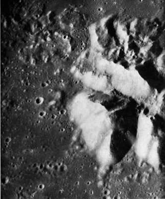 AS 16-4531 - Teophilus' "Peak"
A detailed view of part of the central peak complex of Theophilus. Central peaks are typical of most young, large impact craters on the Moon-and also of many manmade craters on Earth. From experimental data using controlled explosions, central peaks are known to consist of bedrock originally lying below the crater floor that, during the explosion, was uplifted, faulted, and folded by shock wave action. The irregular light-toned mountainous mass projecting above the floor of Theophilus is split into at least three enormous blocks separated by V-shaped structural valleys. Four or five circular craters without a prominent raised rim are located near or at the bases of the steep slopes. If these craters are endogenic vents rather than impact craters, their presence further suggests structural control along major fault planes. The planar walls of the northwest-trending valley contrast with other sloping surfaces of the central peak complex. They are steeper and, except for a few outcrops of protruding bedrock, are marked by linear grooves not unlike slickensides on many fault planes on Earth. Rock chutes do not seem to be a likely explanation for the grooves because there are no talus deposits or blocks at their lower ends. The debris cover is thin enough along the southern valley wall (top of picture) to show that the southern mountain block consists of layered rocks-at least five thick, light-toned layers alternate with thin, dark layers.
Parole chiave: The Moon from orbit - Craters - Teophilus