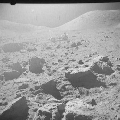AS 17-133-20336 - Moonscape with boulders, rocks and debris
Nei frames precedenti, dopo la prima immagine dedicata all'ombra di un Astronauta e ad un macigno di notevoli dimensioni non lontano da lui, abbiamo incontrato una serie di curiose "sporgenze" - note anche come "affioramenti" o "outcrops" - che caratterizzavano l'interno e le immediate vicinanze di un piccolo cratere. Si tratta di un fenomeno davvero interessante e,a suo modo, anomalo. Peccato che le immagini sono quasi tutte fortemente sovra-esposte. In questo frame, possiamo vedere il LR e, in primissimo piano, accanto a sassi e rocce di varie dimensioni, una serie di chiare impronte lasciate dagli "stivali" degli Astronauti.
Parole chiave: Moon's rocks, sand and debris