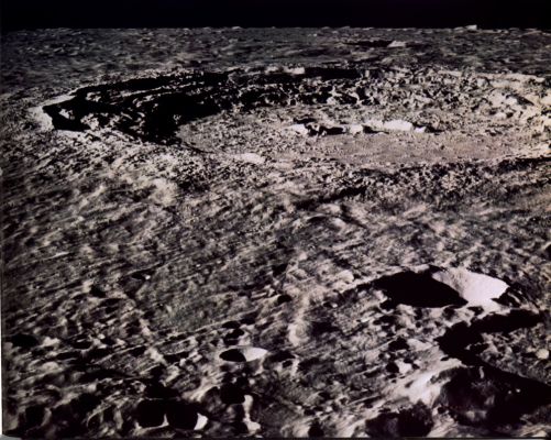 AS 17-151-23260 - Copernicus Crater
The large Crater Copernicus has served as a type example of Lunar Impact Craters since the classic analysis was made by E. M. Shoemaker in 1962. Bright rays of ejecta radiate outward from Copernicus across a large part of the Moon's Near-Side. Material from one of the rays may have been sampled at the Apollo 12 Landing Site, 370 Km South of the center of the crater. This photograph shows how the Crater appeared from the Apollo 17 spacecraft looking Southward over the Montes Carpatus (Carpathian Mountains). 
Notice that the rim deposits immediately adjacent to the Crater have a very crisp, blocky appearance in contrast to the softer appearance of the rest of the ejecta blanket. This crisp zone is also found on many other craters and suggests the ejecta here was swept clean by some erosion process late in the cratering event. The terraced slumps on the Crater wall appear like giant stair steps leading to the floor, 3 to 4 Km below the rim. The 1-Km-high central peaks were made famous in 1966 by a "Picture of the century" view looking into the crater from the south by Lunar Orbiter 2. Now Apollo has given us scores of even more spectacular photographs.
Parole chiave: The Moon from orbit - Craters - Copernicus