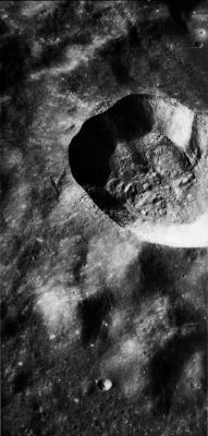 AS 17-2265 - Proclus Crater
This oblique view looks South over the 26-Km-diameter crater Proclus in the highlands at the Western edge of Mare Crisium. Proclus is a young rayed crater that is distinctive because of the marked asymmetry of its ray system-a characteristic visible even in Earth-based telescopic views. The excluded zone is along the South-West edge (top of photograph) but is visible in this moderate Sun photo only as a slight albedo change. Laboratory experiments suggest that a low trajectory angle might account for the asymmetry. A number of large blocks can be seen at the edge of the crater rim. The exceptionally large block (arrow) is about 200 mt wide and, judging from the length of the shadow it casts, nearly as high. As in several other craters shown in this chapter, a darker layer is present in the upper part of the crater wall.
Parole chiave: The Moon from orbit - Craters - Proclus