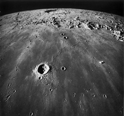 AS 17-2444 - Mare Imbrium & Copernicus Crater
This oblique view across southern Mare Imbrium looks toward Copernicus, the large crater near the horizon. The distance from the lower edge of the picture to the center of Copernicus is 400 km. The mountains at the edge of Mare Imbrium are the Montes Carpatus, and the large crater near the center of the picture is Pytheas, almost 19 km in diameter. Copernicus is one of the youngest of the Moon's large craters. It is visible from Earth, even without the aid of a telescope because of its bright ejecta blanket and its extensive bright rays. The many chains and clusters of small irregular craters and the many bright streaks or rays extending across Mare Imbrium are caused by the secondary impact of debris ejected from Copernicus. The viewing angle accentuates the radial pattern of the secondary impact features. The Sun angle is sufficiently low to show their relief, but high enough to show the contrast between the bright streaks and the normal dark mare surface. As in figure 124, herringbone ridges point toward the primary crater, and the flaring sides of the secondary craters point away from it. The arrow midway between Copernicus and the left edge of the photograph points to a less common pattern of secondary craters; these are concentric to Copernicus.
Parole chiave: The Moon from orbit - Mare Imbrium