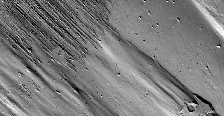 Yardangs in Apollinaris Patera (Original NASA/MGS/MSSS b/w Frame)
Caption NASA originale:"Only a portion of the ejecta remains around this Unnamed Crater. Wind action is creating Yardangs and stripping off the Surface Materials in this Region". 

Image information: VIS instrument;
Latitude: 7,0° South;
Longitude: 173,8° East;
Resolution: 18 meter/pixel.
Parole chiave: Mars from orbit - Aeolian Features - Yardangs in Apollinaris Patera