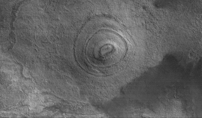 Unusually-looking Butte in Argyre Planitia (Original NASA/MGS/MSSS b/w Frame)
Caption originale:"This MGS-MOC image shows a layered mound, buried under a thin coating of material hard enough to have been cut by shallow fractures, on the floor of the giant Argyre Basin. The material beneath the basin floor is layered; this is an eroded (and then thinly-buried) remnant of some of that layered material".

Location near: 54,2° South Lat. and 46,7° West Long.;
Image width: ~3 Km (~1,9 mi);
Illumination from: upper left.
Season: Southern Summer
Parole chiave: Mars from orbit - Argyre Planitia