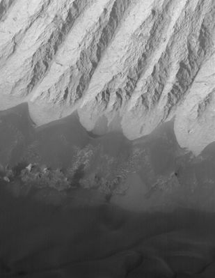 Landforms in Candor Chasma (Original NASA/MGS/MSSS b/w Frame)
Caption NASA originale:"This MGS-MOC image shows dark, windblown sand and an eroded slope of massively-bedded, light-toned, sedimentary rock. These landforms are located in east/central Candor Chasma". 

Location near: 6,8°S; 71,7°W 
Image width: ~3 Km (~1,9 mi) 
Illumination from: upper left 
Season: Southern Spring
Parole chiave: Mars from orbit - Chasmas