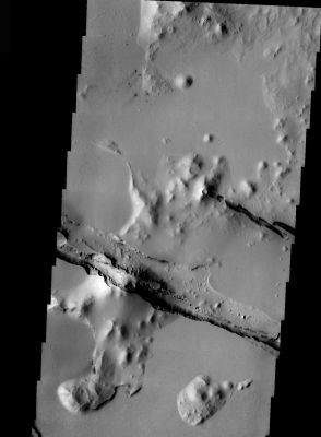 Chaotic Terrain in Cerberus Fossae (Original NASA/JPL/ASU b/w Frame)
Nella Regione Marziana conosciuta con il tenebroso nome di "Cerberus Fossae" possiamo vedere, grazie a questa splendida 'veduta orbitale' ottenuta dalla Sonda NASA "2001 - Mars Odyssey", un terreno ricco di intriganti e variegati rilievi.
Qualche cratere relativamente recente (che reca segni di wind-streaks scuri) e qualcuno più antico e semi-sepolto; delle colline che sembrano poggiare sopra un "basamento" e poi - forse una delle caratteristiche più inquietanti di questo scorcio di Marte - dei profondi e scoscesi crepacci frastagliati. 
Questo tipo di zona viene definito "chaos" e si tratta di un'area che è stata - letteralmente - privata di sostegno sotterraneo e che quindi è "crollata su sè stessa" (---> "Chaos" is typically interpreted to be a collapse terrain; it is the blocky landscape after the transport and removal of subsurface support).
Parole chiave: Mars from orbit - Chaotic Terrain - Cerberus Fossae