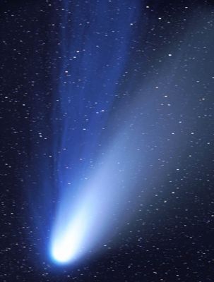 The "Dust" and "Ion" Tails of Hale-Bopp
Lo splendore e la magnificenza della Cometa Hale-Bopp, durante il suo passaggio del 1997. Nell'immagine, vediamo le due code di Hale-Bopp: la  coda ionica (blu intenso), composta da molecole di gas ionizzati - Ã¨ il monossido di carbonio che, quando viene 'eccitato', risplende di luce azzurra - la quale si crea dall'interazione fra le particelle contenute nel Vento Solare ed i gas presenti in prossimitÃ  del nucleo della cometa. La coda ionica, in quanto spinta dal Vento Solare, si muove come una sorta di banderuola e si dirige sempre in posizione diametralmente opposta rispetto al Sole (la sorgente del "Vento"). Anche la coda di polveri (grigio-celeste) segue le leggi della coda ionica, ma essa si orienta in maniera meno netta rispetto al Sole. Questa seconda coda Ã¨ formata da particelle di roccia e polveri - le cui dimensioni variano dal micron al metro ed oltre - staccatisi dal nucleo della cometa durante - ed a causa - della sua "Corsa verso il Sole".
Parole chiave: Comet Hale-Bopp