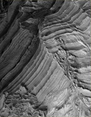 Beautiful Layers inside Becquerel Crater (Original NASA/MGS/MSSS b/w Frame)
Original caption:"This MGS-MOC image shows light-toned, layered, Sedimentary Rock Outcrops in Becquerel Crater , located in the Western Arabia Terra Region. The Crater may once have hosted a lake, into which these sediments were deposited. Although the fine, detailed layering in Becquerel was not known until the MGS-MOC first began to image these materials in 1999, the presence of a grossly-layered, light-toned feature was known from Viking orbiter images and was speculated from those data to possibly represent evidence for the presence of a former lake".

Location near: 21,5° North Lat. and 8,2° West Long.
Image width: ~3 Km (~1,9 mi)
Season: Northern Winter
Parole chiave: Mars from orbit - Craters - Becquerel Crater