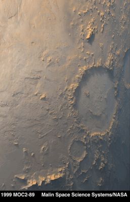 Galle Crater (Saturated Natural Colors; credits: NASA/MGS/MSSS)
Il nome che è stato dato al cratere qui ripreso dal Mars Global Surveyor spiega già tutto: da questa angolazione, infatti, si potrebbe dire che un dotato burlone sia andato a disegnare un bel "viso sorridente" sulla superficie di Marte. Ovviamente si tratta di un semplice effetto ottico determinato dalla particolare prospettiva in cui si trovava la Sonda rispetto al cratere nel momento della ripresa. 
Eppure - credeteci! - c'è stato qualcuno che ha pensato che questa "Faccia Felice" fosse un altro degli enigmatici "Monumenti di Marte", dopo la Sfinge e le Piramidi di Cydonia Mensae.
Parole chiave: Mars from orbit