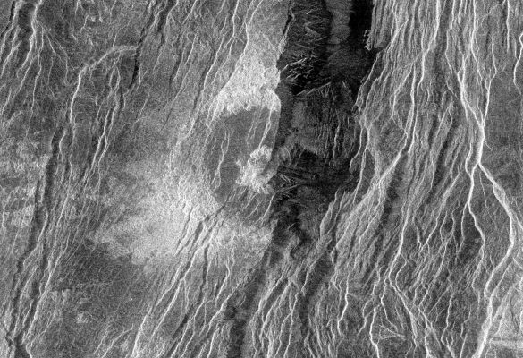 Magellan Probe: radio image of fractured Somerville Crater
Caption NASA originale:"This Magellan radar image is of a 'half crater' located in the rift between Rhea and Theia Montes in Beta Regio on Venus. The unnamed crater is 37 Km in diameter and is located at 29,9° North latitude and 282,9° East longitude. It has been cut by many fractures or faults since it was formed by the impact of a large asteroid. The eastern half of the crater was destroyed during the formation of a fault valley that is up to 20 Km wide and apparently quite deep. A north-south profile through the very center of this crater is visible as a result of the down dropping and removal of the eastern half of the crater". 
Parole chiave: Venus