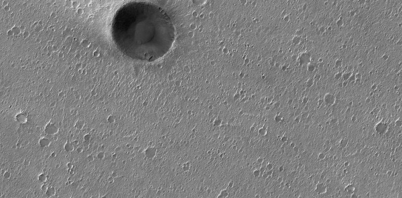 Unnamed Crater in Chrise Planitia (Original NASA/MGS/MSSS b/w Frame)
Caption originale:"This MGS-MOC image shows an impact crater in western Chryse Planitia that is approximately 850 mt (~2790 ft) in diameter, surrounded by a flat plain riddled by hundreds of smaller impact craters".

Location near: 27,6° N; 47,3° W  
Image width: ~3 Km (~1,9 mi)  
Illumination from: lower left  
Season: Northern Winter

Nota: la natura da impatto del cratere ripreso dalla Sonda MGS non può essere, a nostro parere, nè dedotta, nè confutata dalle immagini di cui disponiamo. Ciò che possiamo dire è: qualunque sia l'origine di questo cratere senza nome, come spiegare i curiosi rilievi che sono chiaramente visibili sul suo bordo, ad ore 2, 3 e 6? Si tratta di "gullies"? Diremmo proprio di no. Cedimenti o frane? Difficile dirlo, ma siffatti rilievi, allorchè visti dall'alto, si configurano - di regola - in maniera diversa. 
E che dire, in particolare, delle due formazioni oblunghe visibili ad ore 6 (e simili a due craterini ovali...)? Esse sembrano essere il risultato di attività geologicamente "recenti", a nostro avviso, ma la domanda è "quali attività"? Forse nuovi impatti? Certamente no. E allora? E allora noi rilanciamo l'invito, a Studiosi e Ricercatori, affinchè si inizi una radicale riconsiderazione sulla genesi dei crateri: la teoria dell'impatto funziona SOLO sino ad un certo punto. Poi è notte fonda... 
Parole chiave: Mars from orbit - Craters - Unnamed Crater in Chrise Planitia