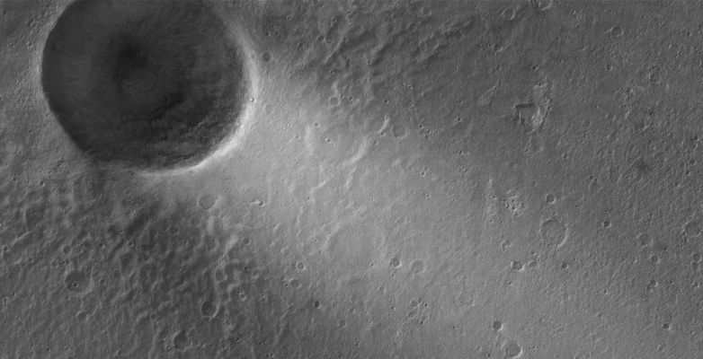 Crater with bright Windstreak in Chrise Planitia (Original NASA/MGS/MSSS b/w Frame)
Caption NASA originale:"This MGS-MOC image shows a (bright) wind streak created in the lee — such as the "downwind" side (ossìa il "lato sottovento") — of a crater in far eastern Chryse Planitia. 
The winds responsible for the formation of the streak blew from the North-East to the South-West".

Location near: 21,5° North; 27,4° West
Image width: ~3 km (~1,9 mi)  
Illumination from: lower left  
Season: Northern Winter
Parole chiave: Mars from orbit - Craters