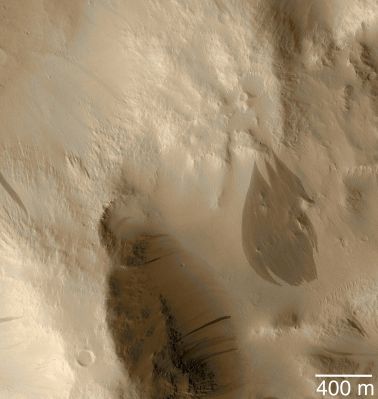 Dark Slope Streaks on the edge of an Unnamed Crater (Saturated Natural Colors; credits: NASA/MGS/MSSS)
Caption NASA originale:"This June 2003 MGS-MOC image shows a crater rim mantled with fine dust near 7.6°N, 171.8°W. Occasional avalanches of dust have created dark streaks that are tapered at their source and broaden downslope. 
A suite of particularly large streaks are seen in the lower right quarter of the picture. The MOC narrow angle camera does not take color images; this full-resolution (1,5 m/pixel; 5 ft/pixel) picture has been "colorized" using data from a previous color image of Mars. 
Sunlight illuminates this scene from the lower left".
Parole chiave: Mars from orbit