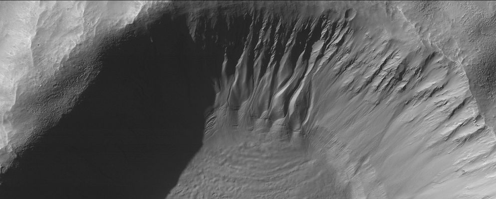 Unnamed Crater with Gullies (Original NASA/MGS/MSSS b/w Frame)
Caption NASA originale:"This MGS-MOC image shows gullies and cracked and stressed gully apron deposits in a South mid-Latitude crater. Gullies can also be seen in the deep shadow on the North wall of the crater. These gullies might have formed by the erosive action of liquid water, sometime in the not-too-distant martian past".  

Location near: 36,7° South; 206,2° West
Image width: ~3 Km (~1,9 mi)  
Illumination from: upper left  
Season: Southern Autumn

Nota: attenzione a quello che la NASA ha scritto in sede di commento: adesso il passato al quale fare riferimento per pensare ad acqua che scorre "allo stato liquido" su Marte non è più remoto (un miliardo di anni o giù di lì); adesso questo passato è "...not too distant..." e cioè "passato prossimo". RicordateVi, in futuro, di quello che stiamo scrivendo da mesi: un frame dopo l'altro ed una parola dopo l'altra, la NASA si sta (lentamente ma) costantemente ridefinendo in chiave possibilista molte delle proprie posizioni (da anni più che consolidate) su molti aspetti/enigmi del Pianeta Rosso.
A quando l'ammissione di una "forma vitale" attuale, magari sotterranea?!?...
Parole chiave: Mars from orbit - Craters - Unnamed Crater with Gullies