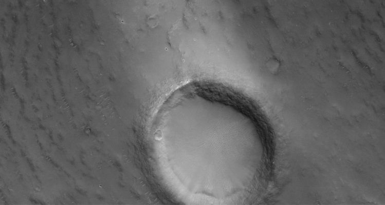 Crater and Windstreak in Syrtis Major Planum (Original NASA/MGS/MSSS b/w Frame)
Caption originale:"This MGS-MOC image shows an Unnamed Crater that is approx. 2 Km in diameter in South Central Syrtis Major Planum. The image also captures a portion of the light-toned Windstreak formed in the Lee (---> lato sottovento) of the Unnamed Cater. The Windstreak is likely composed of a thin coating of Dust".

Location near: 1,9° North Lat. and 294,0° West Long.
Image width: ~3 Km (~1,9 mi)  
Illumination from: upper left  
Season: Northern Summer
Parole chiave: Mars from orbit - Craters