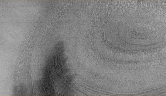 Buried and Frozen (1)
Caption originale:"This MGS-MOC image shows an eroded stack of layered material in a crater of the South Polar Region of Mars. 
The composition of the layers is not known; some speculate that they may contain a combination of dust and ice, or possibly ancient sedimentary rock".

Location near: 80,6° South; 230,4° West
Image width: ~3 Km (~1,9 mi)  
Illumination from: upper left  
Season: Southern Summer
Parole chiave: Mars from orbit - South Polar Features - buried crater