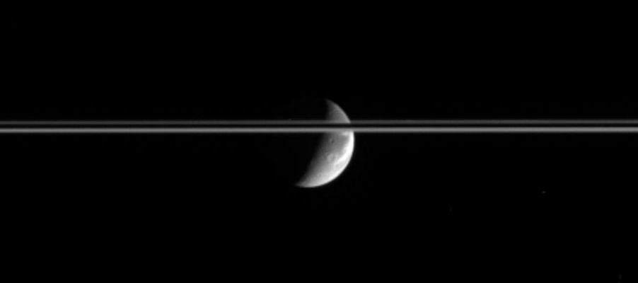 Icy cliffs in the Sun...
After journeying a bit more than an hour across the Solar System, bright Sunlight reflects off the gleaming icy cliffs in the wispy terrain of Dione and is captured by the Cassini spacecraft's cameras several light seconds later. 
Saturn's Ring-Plane is here tilted slightly toward the Cassini spacecraft and is bisected by the Planet's dark shadow stretching across the Rings. 
This view looks toward the Saturn-facing Hemisphere on Dione. 

The image was taken in visible light with the Cassini spacecraft narrow-angle camera on Dec. 3, 2005, at a distance of approx. 2,8 MKM (about 1,7 MMs) from Dione and at a Sun-Dione-spacecraft, or phase, angle of 104°. Resolution in the original image was roughly 17 Km (such as about 11 miles) per pixel on Dione. The image has been magnified by a factor of two and contrast-enhanced to aid visibility".
Parole chiave: Saturn's Moons - Dione
