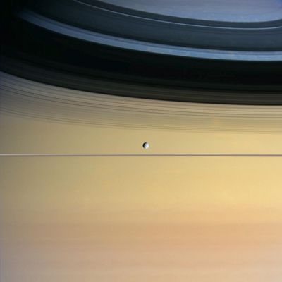 Black&White&Colors: Dione and Saturn
Cool and icy Dione floats in front of giant Saturn bedecked in a dazzling array of colors. 
The surface of Dione, which exhibits contrasting bright and dark areas when viewed up close, appears pale in this image. It is Saturn's multi-hued cloud bands that boldly steal the show. Discrete clouds and eddies in Saturn's Northern Hemisphere can be seen within the faint shadows of the Rings on the Planet. Cassini is in a phase of its mission in which its orbit will be nearly equatorial for some time. This view was obtained from about 1/3ed of 1° out of the Ring-Plane.

Images taken with red, green and blue filters were used to create this natural-color view. 
The images were obtained with the wide-angle camera on Sept. 22, 2005, from a distance of approx. 803.000 Km (roughly 499.000 miles) from Dione and at a phase angle of about 43°. 
The image scale is about 48 Km (30 miles) per pixel.
Parole chiave: Saturn and Dione
