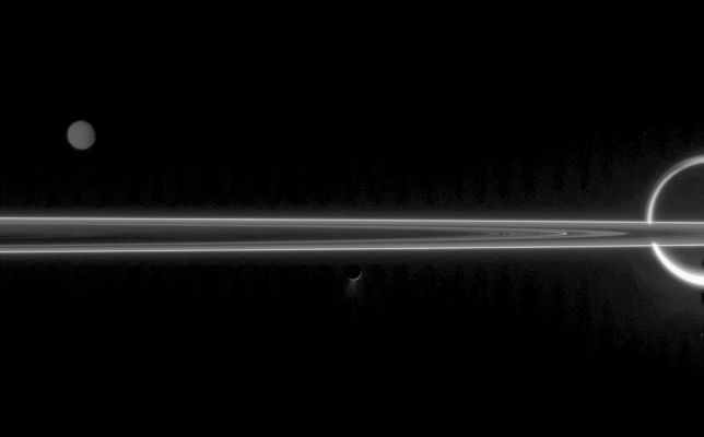 Jewels...
The real jewels of Saturn are arguably its stunning collection of icy moons. Seen here with the unlit side of the Rings are Titan (Dx), Tethys (Sx) and Enceladus (Cn) with its fountain-like geysers. 
The faint, vertical banding in the image is due to "noise" in the spacecraft electronics. This noise is difficult to remove from an image that has a very wide dynamic range - i.e.: a wide range of brightness levels - as in the difference between gleaming Titan and the faint plumes of Enceladus. 
Additionally, a reflection of Titan's light within the camera optics is likely responsible for the faint secondary image of Titan's limb to the left of the giant moon. 

The image was taken in visible green light with the Cassini spacecraft narrow-angle camera on June 10, 2006 at a distance of approx. 3,9 MKM (about 2,4 MMs) from Enceladus; 5,3 MKM (about 3,3 MMs) from Titan and 4,4 MKM (such as approx. 2,7 MMs) from Tethys. 
The phase angle is 160° on Enceladus. 

Image scale is 23 kilometers (14 miles) per pixel on Enceladus, 32 kilometers (20 miles) per pixel on Titan and 26 kilometers (16 miles) per pixel on Tethys. 
Parole chiave: Saturn's Moons - Tethys, Enceladus and Titan