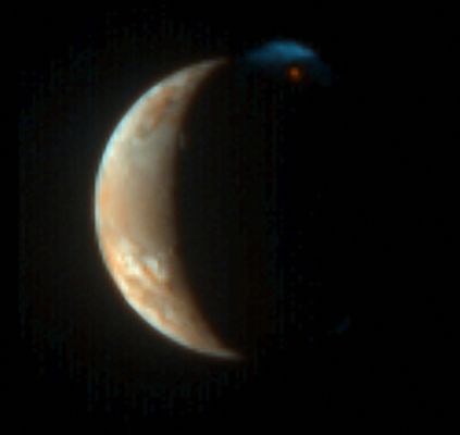 Burning Io!
New Horizons captured this unique view of Jupiter's moon Io with its color camera - the Multispectral Visible Imaging Camera (MVIC) - at 00:25 UT on March 1, 2007, from a range of 2,3 MKM (about 1,4 MMs). The image is centered at Io coordinates 4°South lat. and 162° West Long., and was taken shortly before the complementary Long Range Reconnaissance Imager (LORRI) photo of Io released on March 13, which had higher resolution but was not in color.
Like that LORRI picture, this processed image shows the nighttime glow of the Tvashtar volcano and its plume rising 330 kilometers (200 miles) into sunlight above Io's north pole. However, the MVIC picture reveals the intense red of the glowing lava at the plume source and the contrasting blue of the fine dust particles in the plume (similar to the bluish color of smoke), as well as more subtle colors on Io's sunlit crescent. The lower parts of the plume in Io's shadow, lit only by the much fainter light from Jupiter, are almost invisible in this rendition. Contrast has been reduced to show the large range of brightness between the plume and Io's disk.

A component of the Ralph imaging instrument, MVIC has three broadband color filters: blue (480 nanometers), red (620 nm) and infrared (850 nm); as well as a narrow methane filter (890 nm). Because the camera was designed for the dim illumination at Pluto, not the much brighter sunlight at Jupiter, the red and infrared filters are overexposed on Io's dayside. This image is therefore composed from the blue and methane filters only, and the colors shown are only approximations to those that the eye would see. Nevertheless, the human eye would easily see the red color of the volcano and the blue color of the plume.

Parole chiave: Jupiter's Moons - Io