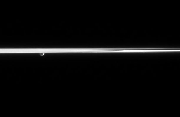 Janus and the Rings
Caption NASA originale:"Janus peeks out from beneath the Ring-Plane, partially lit here by reflected light from Saturn. A couple of craters can be seen on the moon's surface. To the right, two faint clumps of material can be seen in the dynamic F-Ring. 
The perspective in this view may be a bit confusing -- from just below the Ring-Plane, Cassini is gazing toward Janus (181 Km, or 113 miles across), which is behind the Rings. 

The image was taken in visible light with the Cassini spacecraft narrow-angle camera on March 16, 2006, at a distance of approx. 2,1 MKM (such as about 1,3 MMs) from Janus and at a Sun-Janus-spacecraft, or phase, angle of 103°. Image scale is approx. 12 Km (about 8 miles) per pixel".
Parole chiave: Saturn's Moons - Janus
