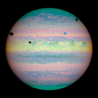 Triple eclypse on Jupiter (false colors - HST)
Da "NASA - Picture of the Day" dell'11.11.2004: "This false-color image of banded gas giant Jupiter shows a triple eclipse in progress on March 28 - a relatively rare event, even for a large planet with many moons. Captured by the Hubble Space Telescope's near-infrared camera are shadows of Jupiter's moons Ganymede (left edge), Callisto (right edge) and Io, three black spots crossing the sunlit Jovian cloud tops. In fact, Io itself is visible as a white spot near picture center with a bluish Ganymede above and to the right, but Callisto is off the right hand edge of the scene. Viewed from Jupiter's perspective, these shadow crossings would be seen as solar eclipses, analogous to the Moon's shadow crossing the sunlit face of planet Earth. Historically, timing the eclipses of Jupiter's moons allowed astronomer Ole Roemer to make the first accurate measurement of the speed of light in 1676". 
Parole chiave: Hubble Images - Jupiter