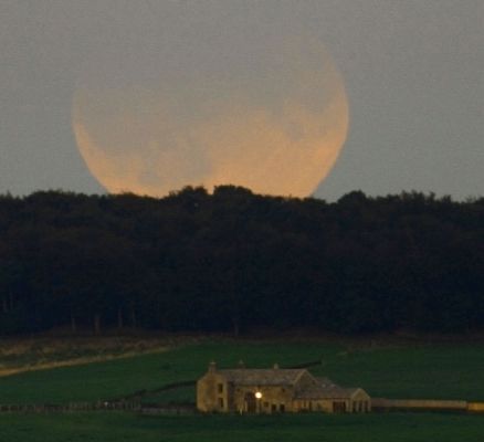 Lunar Eclipse over England
Da "NASA - Picture of the Day", dell'11 Settembre 2006:"Last Thursday - Sept., 7th, 2006 -, part of our Moon turned dark. The cause, this time, was not a partial lunar phase - the Moon was full - but rather that part of the Moon went into Earth's shadow. The resulting Partial Lunar Eclipse was visible from the Eastern Atlantic Ocean through Europe, Africa and Asia and into the Western Pacific Ocean. The darkest part of the Lunar Eclipse, when part of the Moon was completely shielded from Sunlight, lasted about 90 minutes. 
Pictured here, a partially eclipsed Moon is seen rising over an estate in Huddersfield, England. The above image was taken far away from the house in the foreground, as only this would allow it to appear as angularly small as the half-degree Moon far in the background. A setting twilight Sun lit the foreground. The next eclipse of the Moon will occur in March 2007".
Parole chiave: From Earth Pictures - Amatorial Pictures