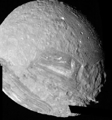 Miranda from Voyager 2
In questo nuovo frame potete apprezzare il fatto che Miranda ha più la forma di un uovo che quella di una sfera. Le fotografie che possediamo di questo corpo celeste ci fanno vedere un mondo profondamente segnato da impatti: impatti che hanno provocato profondissime "cicatrici" le quali, come si diceva in sede di commento all'immagine precedente, sono ancora ben visibili. 
La enorme depressione a cui avevamo già accennato è ora visibile con maggiore chiarezza, sulla Vostra Sn. A giudicare dalle sue fattezze possiamo supporre che si sia (forse) trattato di un "urto radente", ossìa il corpo celeste che ha impattato Miranda avrebbe dovuto avere, al momento del contatto, un angolo di incidenza, rispetto al piano dell'orizzonte di Miranda stessa, molto basso (inferiore ai 35°?). Ed è forse per questo motivo che, nonostante la catastrofica collisione, Miranda è, si, rimasta profondamente segnata, ma NON si è completamente disintegrata...
Parole chiave: Uranus Moons