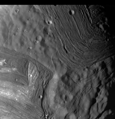 "Chevron grooves" on Miranda - HR
Caption NASA originale:"This image of Miranda, obtained by Voyager 2 on approach, shows an unusual 'chevron' figure and regions of distinctly differing terrain on the Uranian moon. Voyager was 42.000 Km (26.000 miles) away when its narrow-angle camera acquired this clear-filter view. Grooved areas baring light and dark bands, distinct from other areas of mottled terrain, are visible at this resolution of about 600 meters (2.000 feet). The bright V-shaped feature in the grooved areas is the 'chevron' observed in earlier, lower-resolution images. Cutting across the bands are sinuous scarps, probably faults. Superimposed on both types of terrain are many bowl-shaped impact craters less than 5 Km (3 mi) wide. The entire picture spans an area about 220 Km (140 mi) across". 
Parole chiave: Uranus' Moons - Miranda
