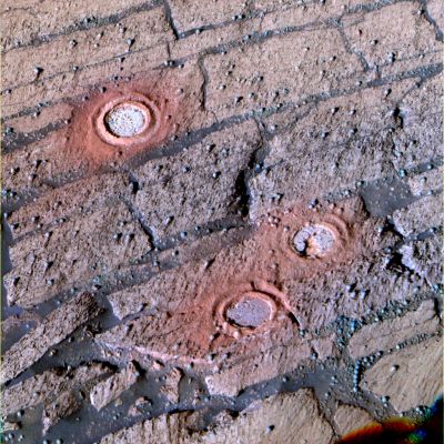Layers inside Endurance (enhanced colors) - Sol 143
Caption NASA originale:"This enhanced-color PanCam image from the Rover Opportunity features 3 holes created by the RAT between Sol 143 and Sol 148 (June 18 and June 23, 2004) inside Endurance Crater. 
The enhanced image makes the red colors a little redder and blue colors a little bluer, allowing viewers to see differences too subtle to be seen without the exaggeration. When compared with an approximately true color image, the tailings from the RAT and the interior of the abraded holes are more prominent in this view. Being able to discriminate color variations helps scientists determine rocks' compositional differences and texture variations".
Parole chiave: Endurance Crater - The Inner Walls