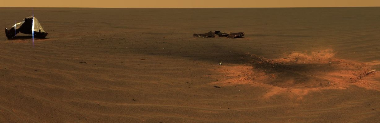 The "Opportunity Crater" - Sol 330 (Approximate Natural Colors; credits: NASA/JPL-Caltech)
Caption NASA originale:"This is an approximately true-color mosaic of panoramic camera images taken through the camera's 750, 530 and 430-nanometer filters. On the left, the main Heat Shield piece is inverted and reveals its metallic insulation layer, glinting in the sunlight. The main piece stands about 1 mt tall and about 13 mt from the Rover. The other large, flat piece of debris near the center of the image is about 14 mt away. The circular feature on the right side of the image is the crater made by the heat shield's impact. It is about 2,8 mt in diameter but only 5 to 10 cm deep. The "Man-made Crater" is about 6 mt from Opportunity in this view". Dunque è sufficiente il treno di ruotine del Rover per intaccare profondamente il suolo di Meridiani Planum mentre l'impatto - non frenato!!! - di un rottame pesante qualche quintale scava un cratere di soli 5/10 cm di profondità... 
A noi sembra che qualcosa non quadri proprio a perfezione in questo scenario...
Parole chiave: Heat-Shield and surroundings